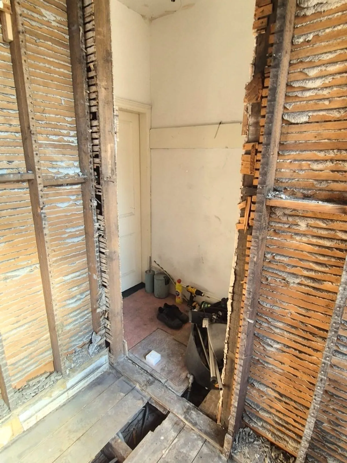 Lath and plaster removed from a partition wall, exposing the timber studwork